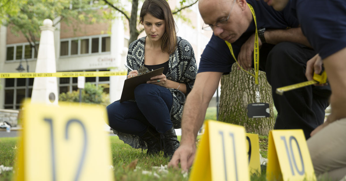 Forensic medicine grad students and faculty investigate a mock crime scene outside at PCOM's Philadelphia campus