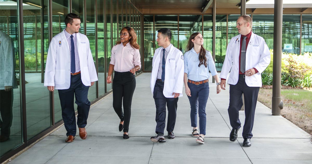 PCOM South Georgia med students giving a tour to prospective students as they walk through the courtyard