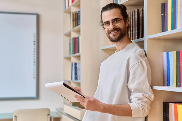 A PCOM school psychology graduate student smiles as he takes notes in a classroom