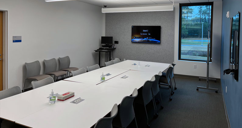 Debriefing room Long conference table, chairs and large flat screen monitors in the PCOM South Georgia Sim Center's debriefing room